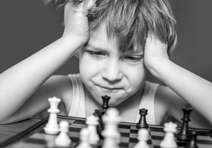 bigstock-Boy-playing-chess-thinking-ho-44129230