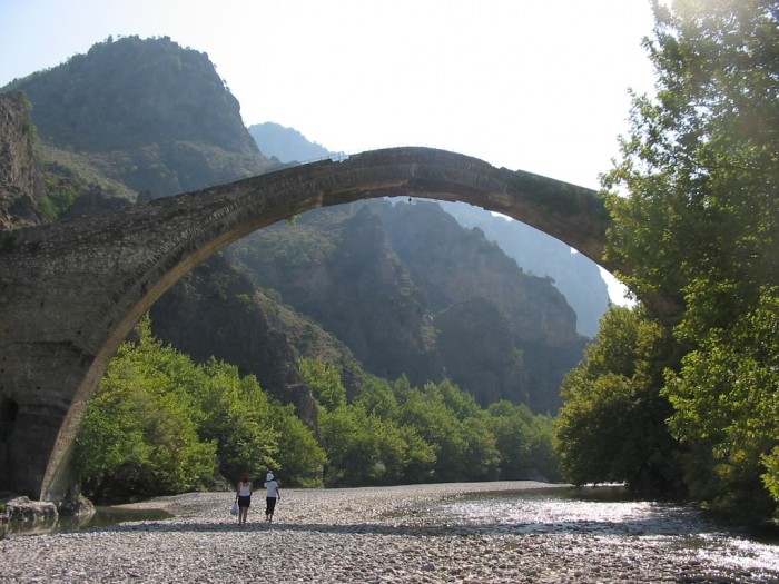 The Old Bridge of Konitsa It is built in Greece. It crosses over the river Aoos. It is very dangerous to cross this bridge when there is a strong wind and this is why there is a bell which is hung under the bridge for warning people. 