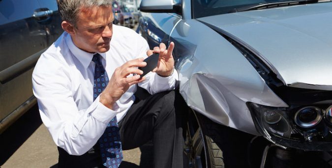 Loss Adjuster Inspecting Car Involved In Accident Taking A Photo Of Damage Vehicle