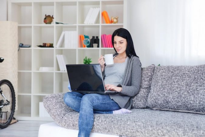 woman using laptop The Ultimate Decorating Guide for Your Living Room - 2