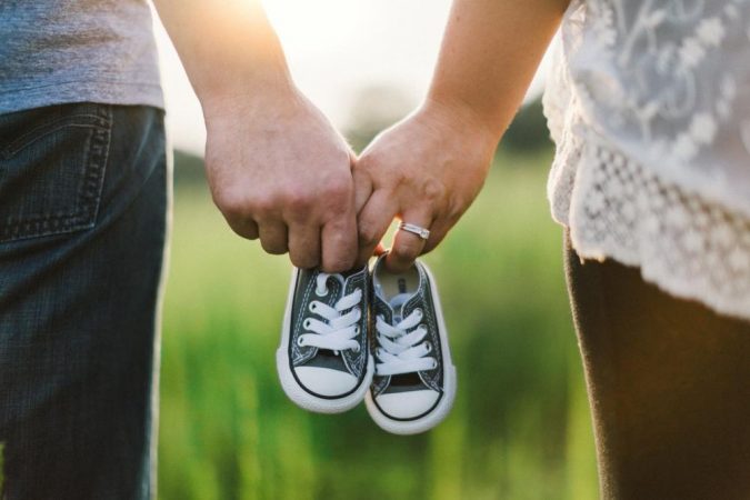 a mom and dad holding baby shoes Facing Infertility Feelings: Choosing Frozen Donor Egg IVF - 10