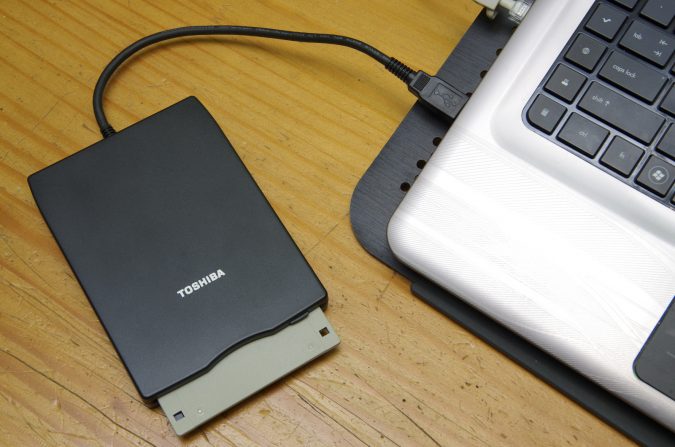 Floppy drive connected to laptop Top 10 Outdated Technologies That are Coming Next Year - 11 Outdated Technologies
