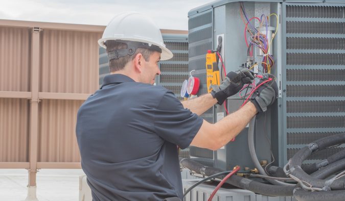 furnace technician working on heat pump Top 10 US Areas Need Furnace Repair services - 8