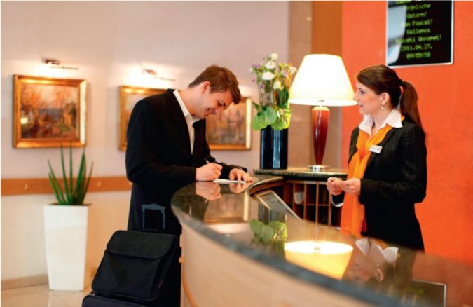 hotel receptionist and resident Top 10 Exclusive Tips to Find Cheapest Hotel Deals - 4