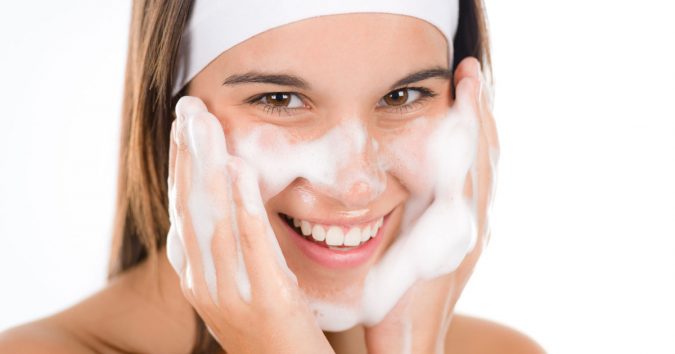 woman washing her face acne Protect Your Skin from Acne Caused by Face Mask with Simple Remedies - 4