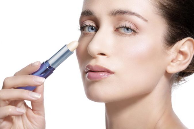 woman applying skin concealer 7 Tricks to Keep Your Lipstick Last Longer - 11