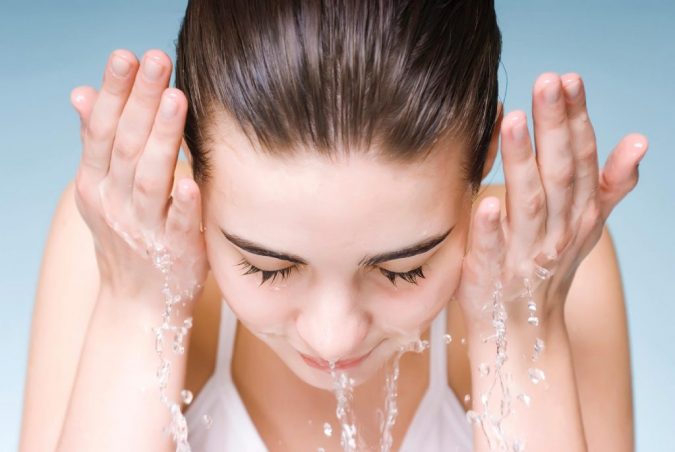 woman washing her face preparing for makeup Protect Your Skin from Acne Caused by Face Mask with Simple Remedies - 2