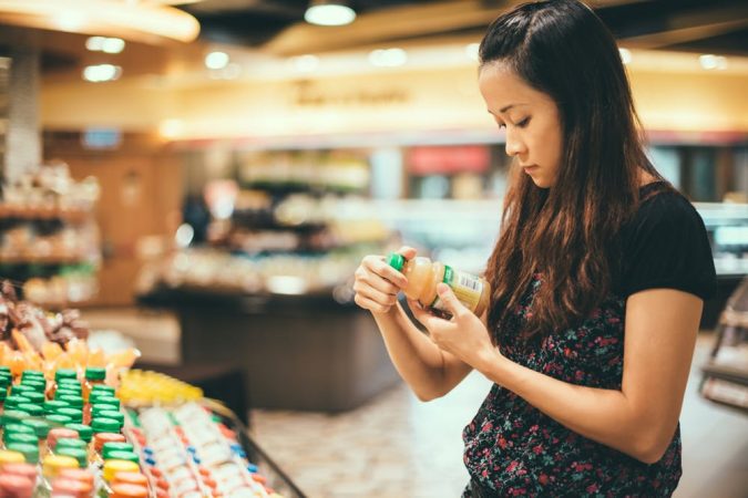 10 Things to Consider Before Buying Food for Your Family 18 shopping woman reading nutrition label Getty 10 Things to Consider Before Buying Food for Your Family - 18