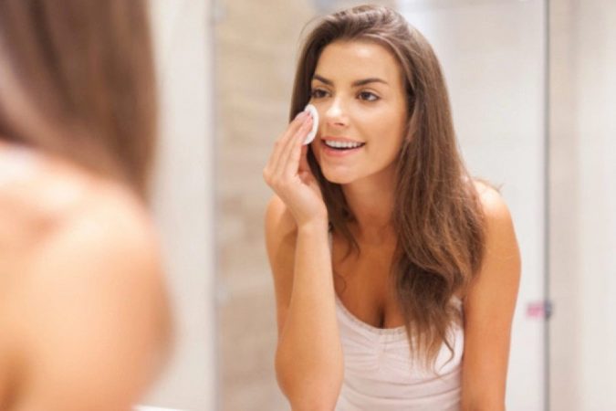 woman applying makeup 10 Tips to Hide Acne with Makeup - 16