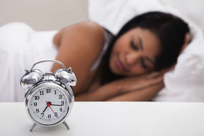 sleep clock sleeping woman 7 Positive Benefits of Taking CBD Gummies - 5