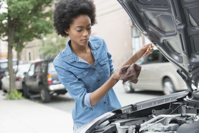 woman checking car 10 Essential Car Maintenance Tips That You Should Know - 5
