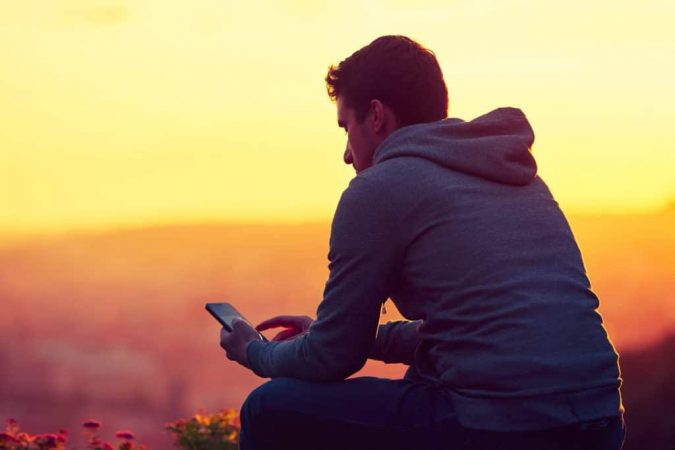 man holding mobile What Expats Should Know Before Returning Home - 5