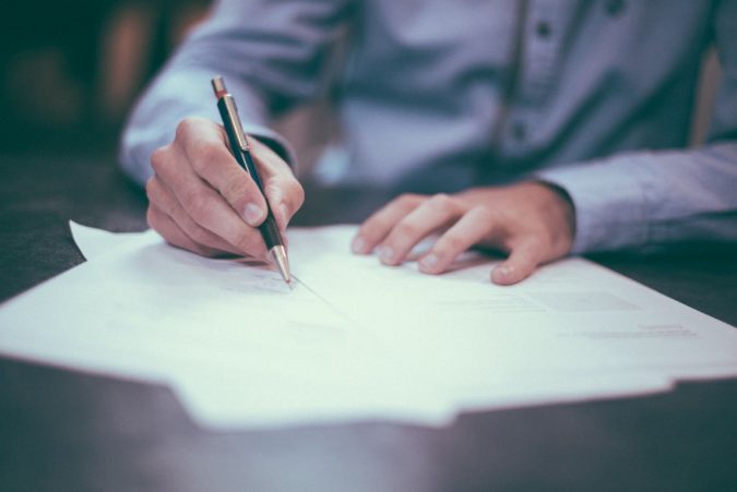 man writing filling paperwork What Expats Should Know Before Returning Home - 9