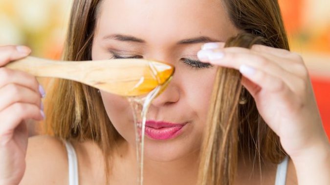 young woman using honey in her hair 15 Natural Hair Beauty Tips for All Hair Types - 20