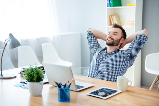 6 Ways to Stay Healthy on a Busy Schedule 7 a man relaxing at his desk at work 1 6 Ways to Stay Healthy on a Busy Schedule - 7
