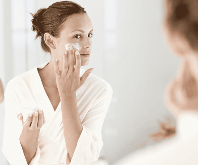 woman moisturizing her face How to Look Your Best While Wearing a Mask – Tips for Men and Women - 2