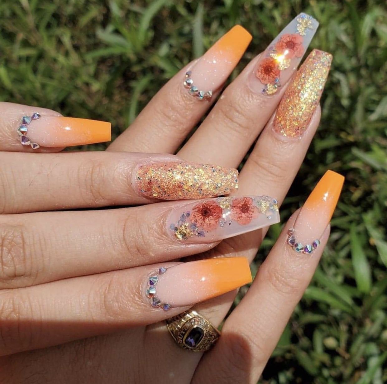 3D acrylic nail design with flower lined with orange color